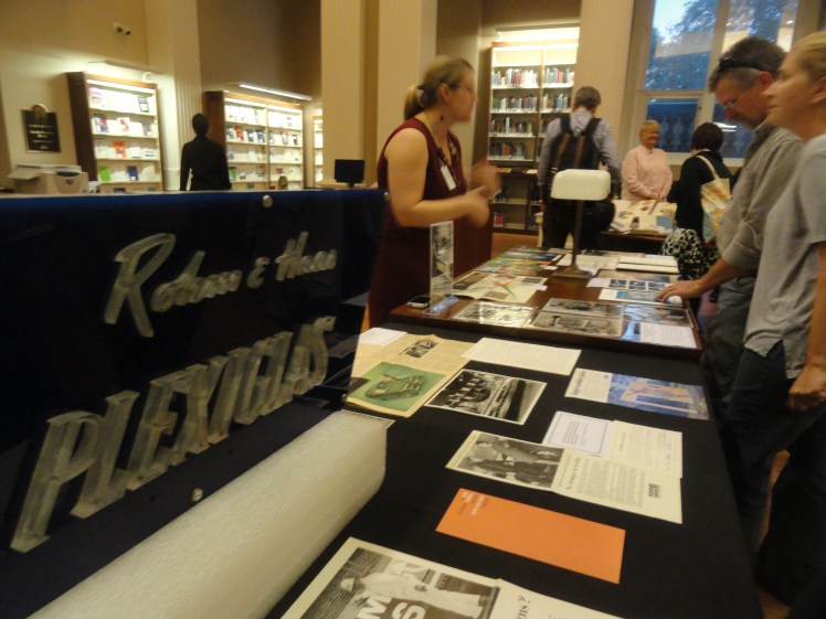 a Plexiglass sign and vintage ads on display