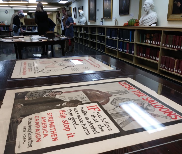 Temperance posters on a table with event attendees in the background.