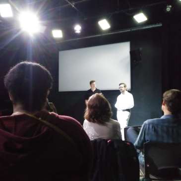 Speakers in front of room discussing film.