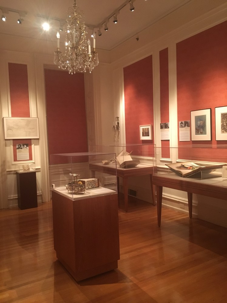 Exhibit at the Rosenbach. Books in class cases with crystal chandelier hanging from center of the room.