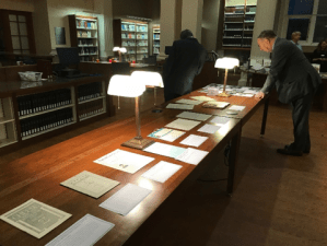 Person viewing documents laid out on table.