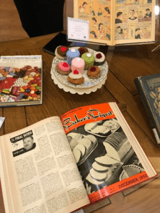 Cupcakes and books laid on a table.